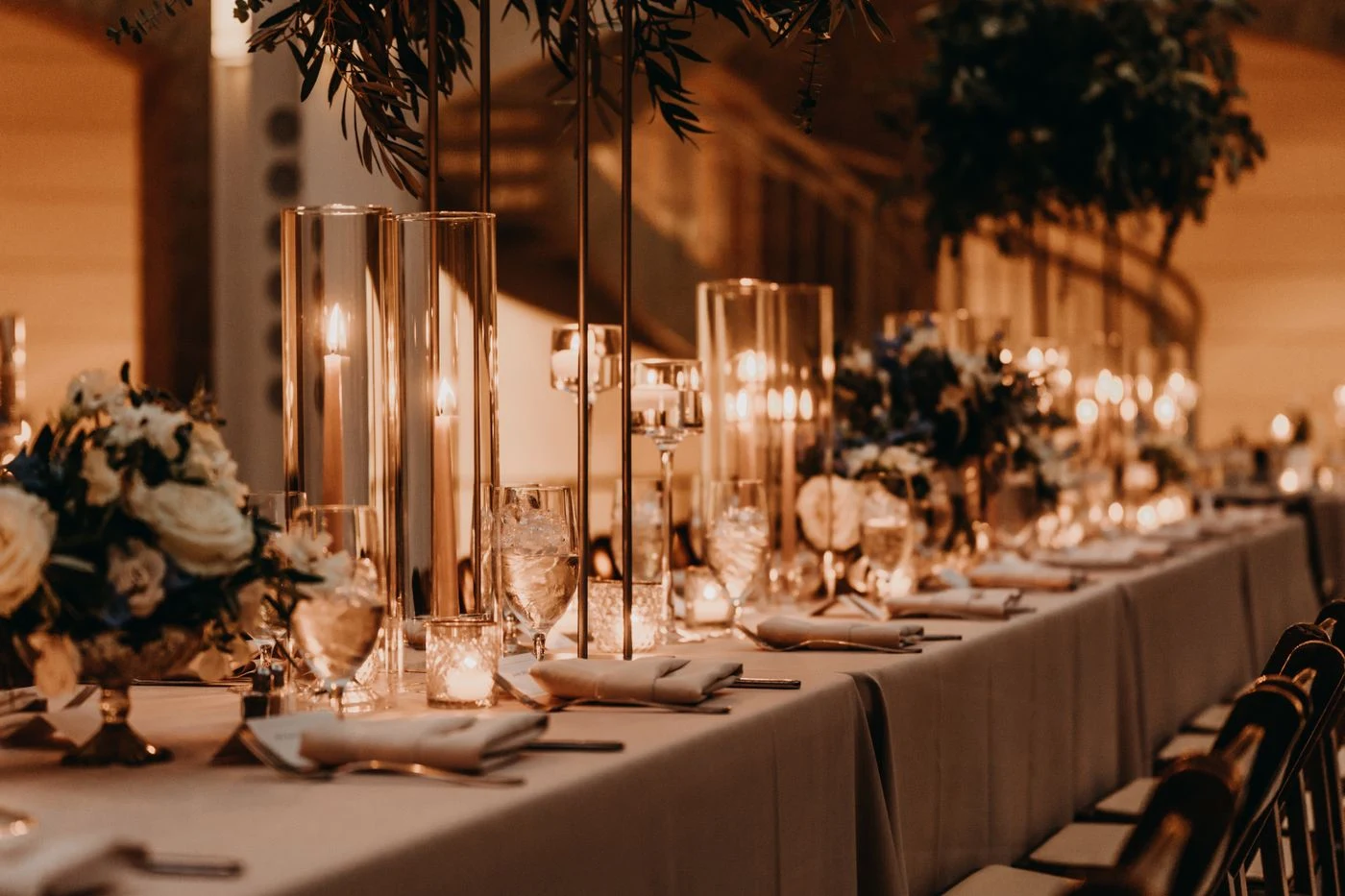 Candlelit gala table with ivory linens, crystal glassware and white flowers